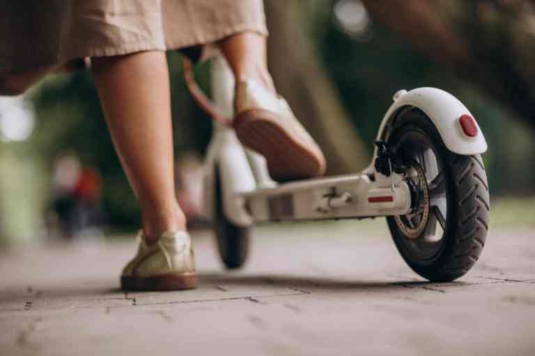 young-woman-riding-scooter-in-park-feet-close-up